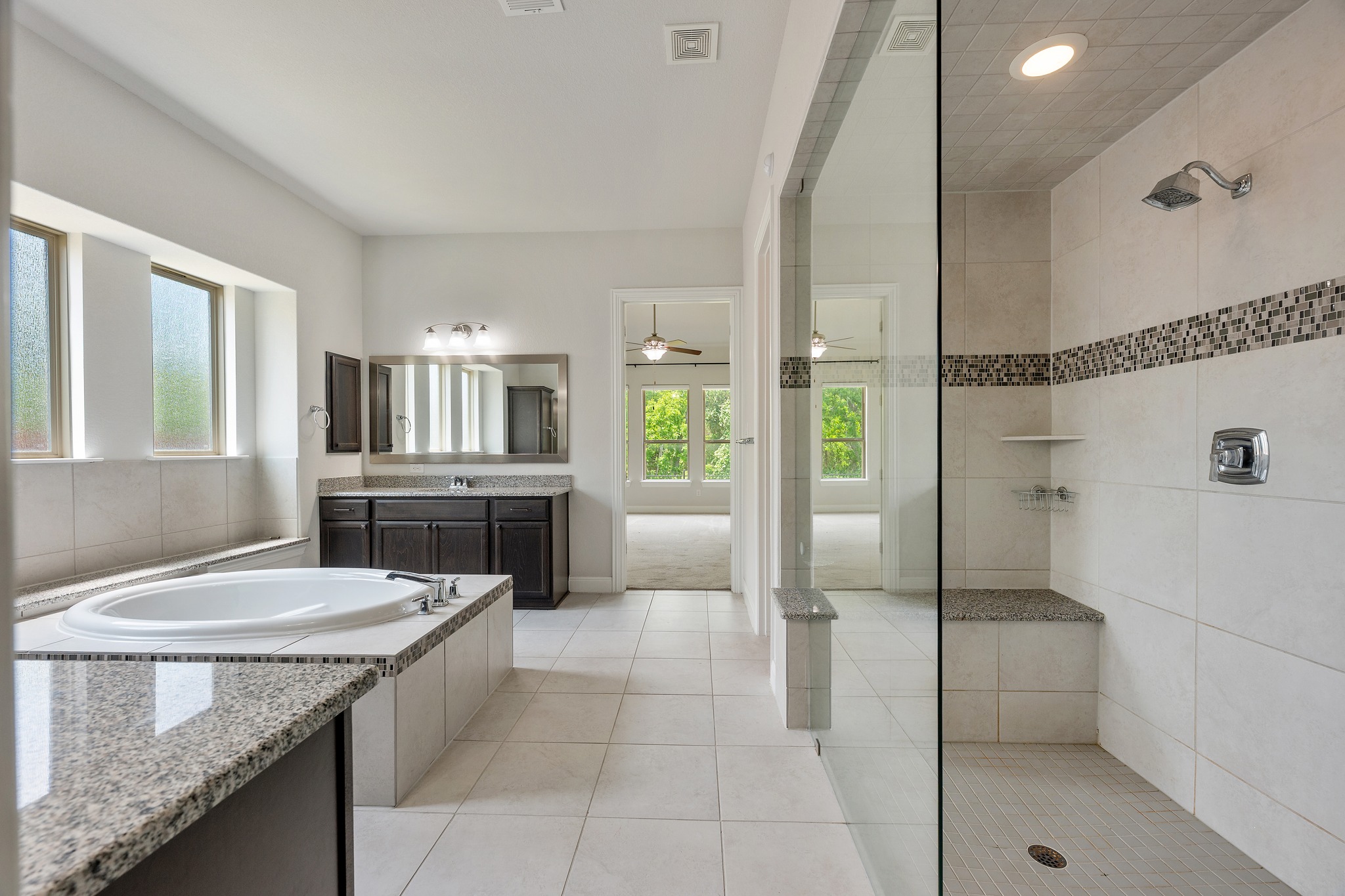 2709 Steece Way Leander, TX 78641 - Photo 28 of 39 a bathroom with a granite countertop sink a mirror and a bathtub
