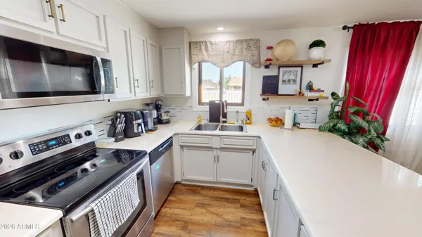 a kitchen with stainless steel appliances a stove microwave and sink