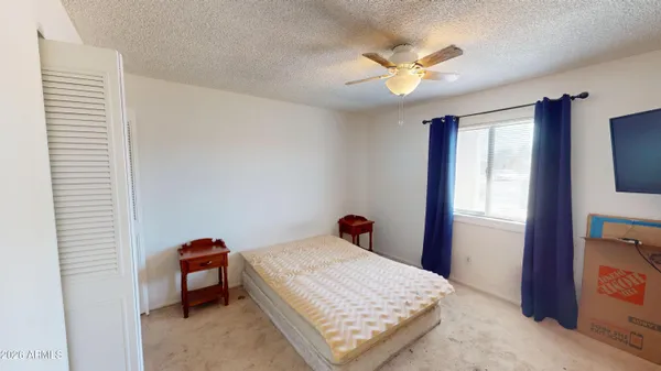 a bedroom with a bed and a ceiling fan