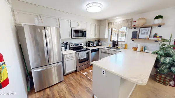 a kitchen with stainless steel appliances a refrigerator sink and microwave