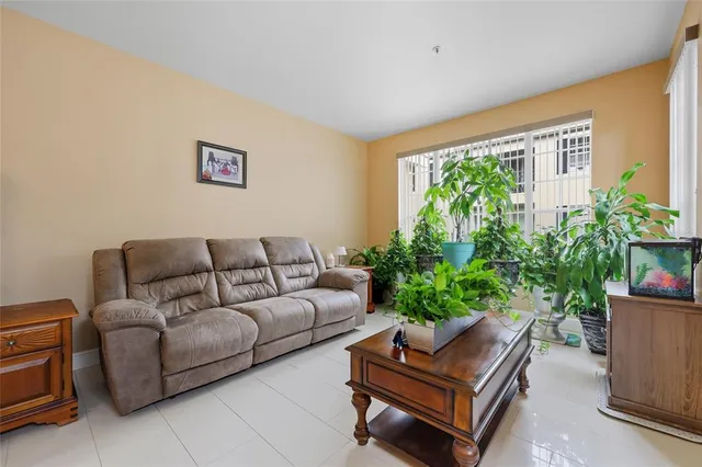 a living room with furniture and a potted plant
