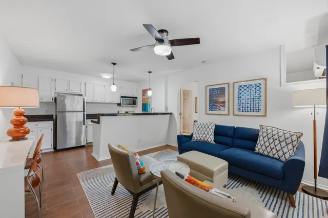 a living room with furniture and kitchen view