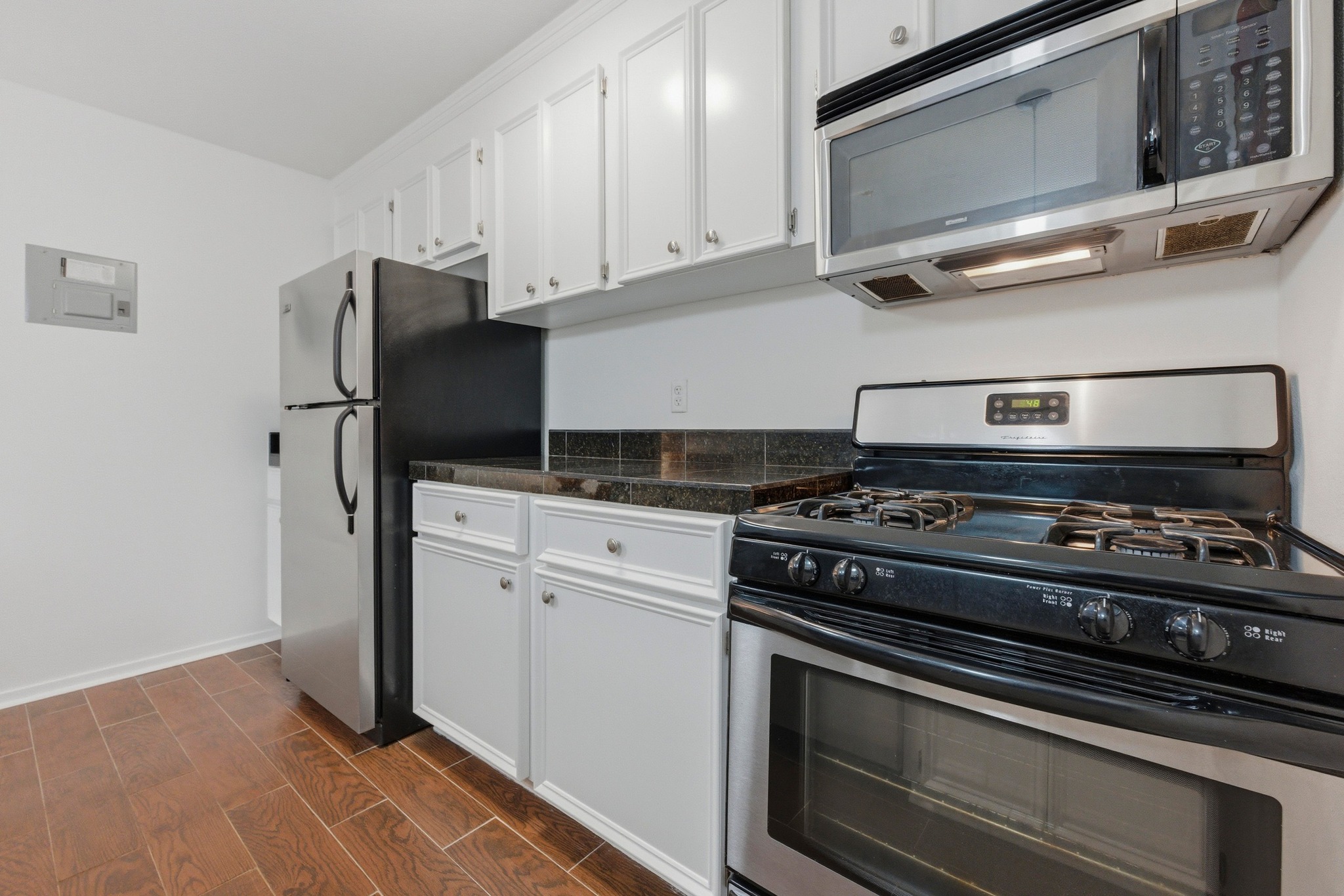 304 East 33rd Street, Unit 11 Austin, TX 78705 - Photo 10 of 27 a kitchen with stainless steel appliances granite countertop a stove and a microwave