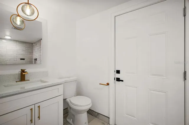 a bathroom with a sink a toilet and a mirror