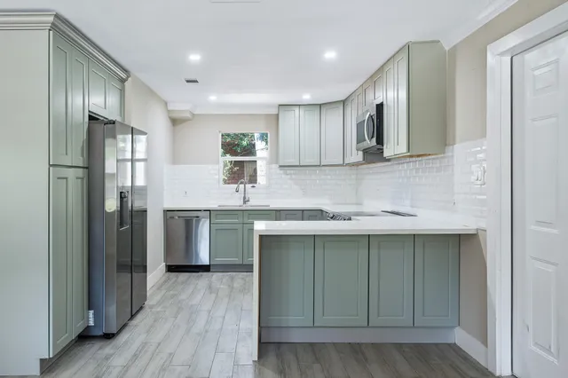 a kitchen with stainless steel appliances granite countertop a sink stove and refrigerator