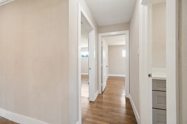 a view of a hallway with wooden floor