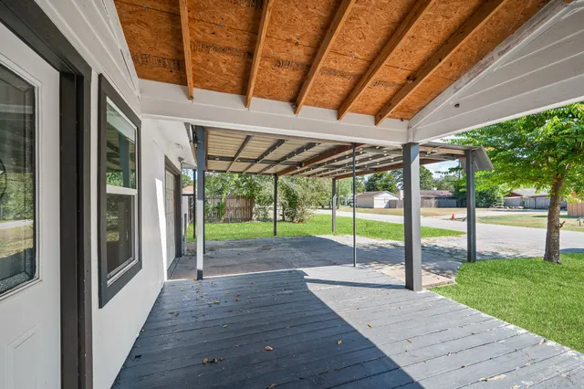 a view of a porch with wooden floor and roof