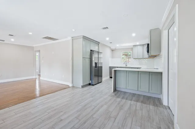a kitchen with stainless steel appliances a refrigerator sink and cabinets
