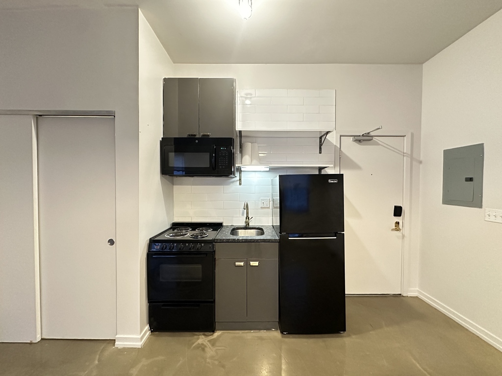 1136 West Wilson Avenue, Unit 202 Chicago, IL 60640 - Photo 3 of 19 a kitchen with a refrigerator and a stove top oven
