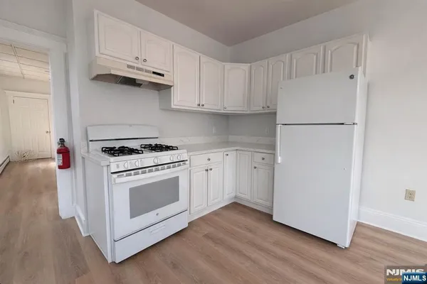 a kitchen with white cabinets and white appliances