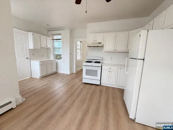 a kitchen with white cabinets and white appliances