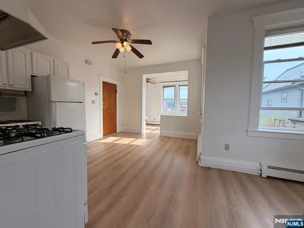 a kitchen with stainless steel appliances a stove a refrigerator and wooden floor