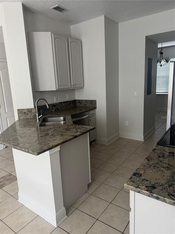 12976 Borland Street Windermere, FL 34786 - Photo 5 of 15 a kitchen with granite countertop a sink and a stove