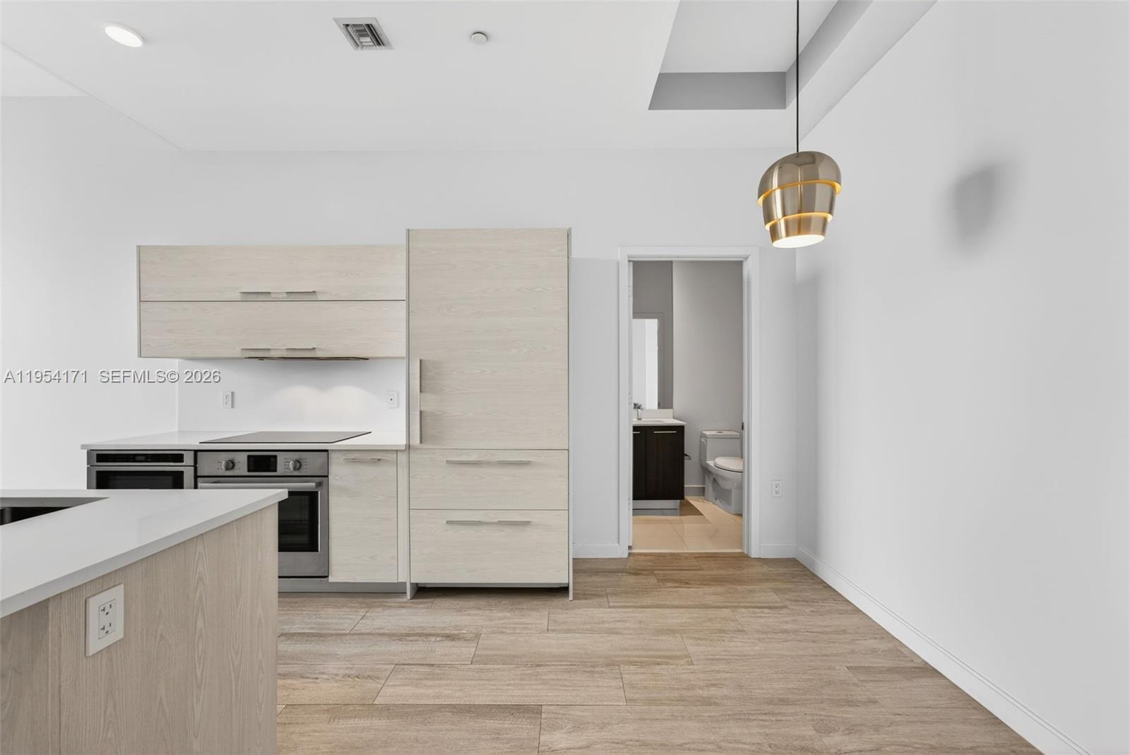 45 Southwest 9th Street, Unit LPH4609 Miami, FL 33130 - Photo 16 of 50 an empty room with wooden floor kitchen view and a window
