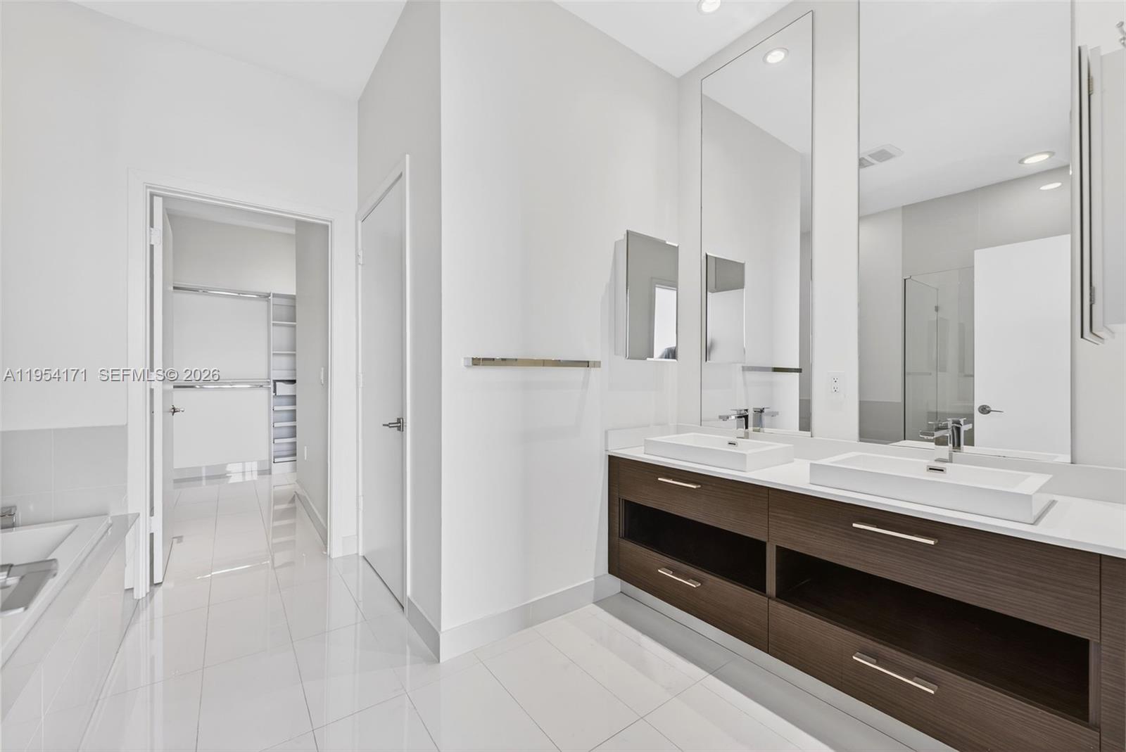 45 Southwest 9th Street, Unit LPH4609 Miami, FL 33130 - Photo 22 of 50 a spacious bathroom with a double vanity sink a mirror and a shower