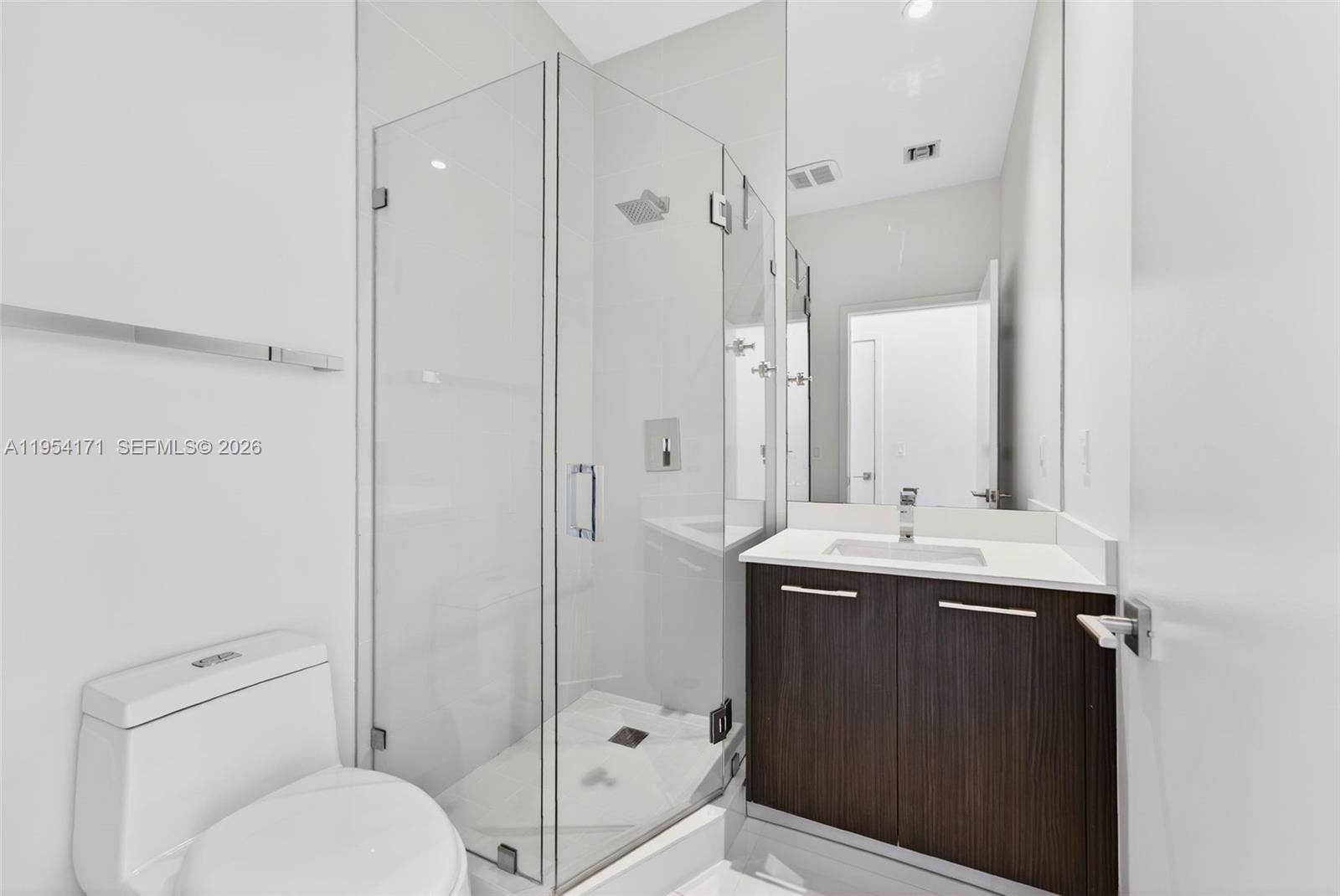 45 Southwest 9th Street, Unit LPH4609 Miami, FL 33130 - Photo 27 of 50 a bathroom with a granite countertop sink toilet a mirror and shower