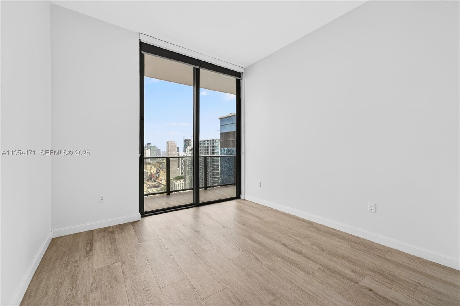 45 Southwest 9th Street, Unit LPH4609 Miami, FL 33130 - Photo 32 of 50 an empty room with wooden floor and windows