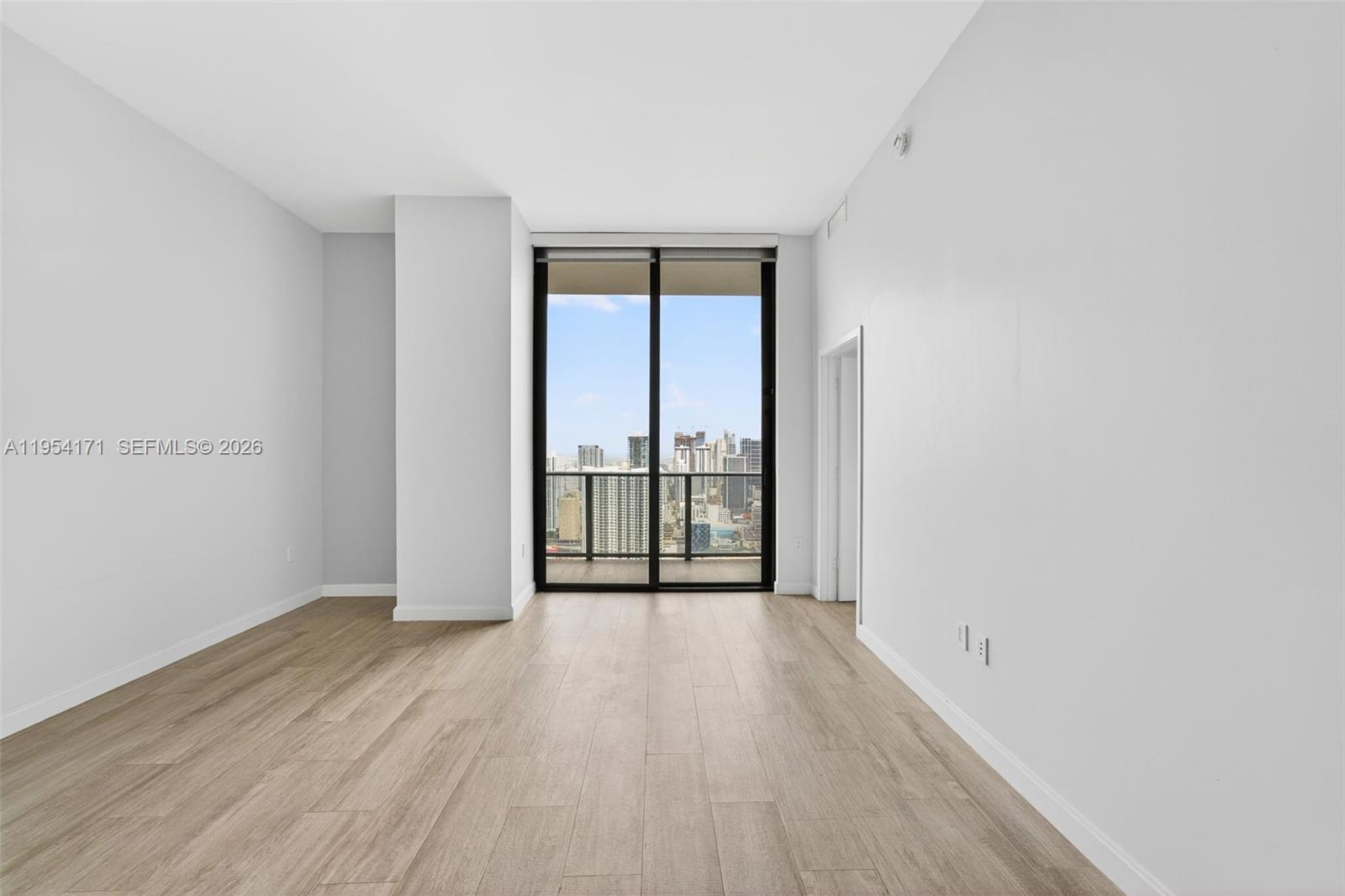 45 Southwest 9th Street, Unit LPH4609 Miami, FL 33130 - Photo 10 of 50 wooden floor in an empty room with a window