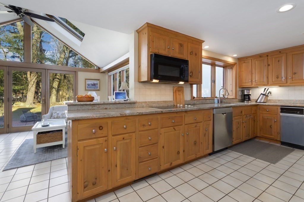 8 Townsend Road Lynnfield, MA 01940 - Photo 18 of 41 a kitchen with stainless steel appliances granite countertop a sink and a stove top oven with granite countertops