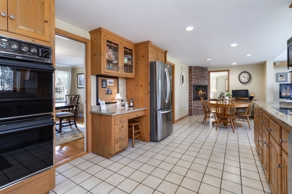8 Townsend Road Lynnfield, MA 01940 - Photo 19 of 41 a kitchen with stainless steel appliances kitchen island granite countertop a refrigerator and a stove top oven