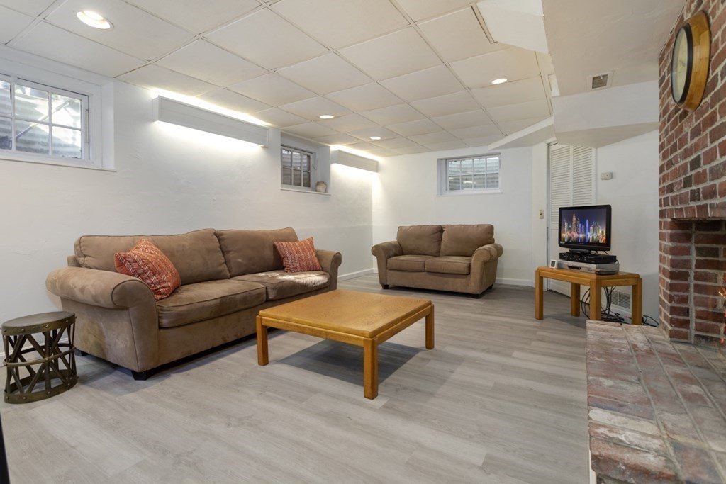 8 Townsend Road Lynnfield, MA 01940 - Photo 30 of 41 a living room with furniture a flat screen tv and a fireplace