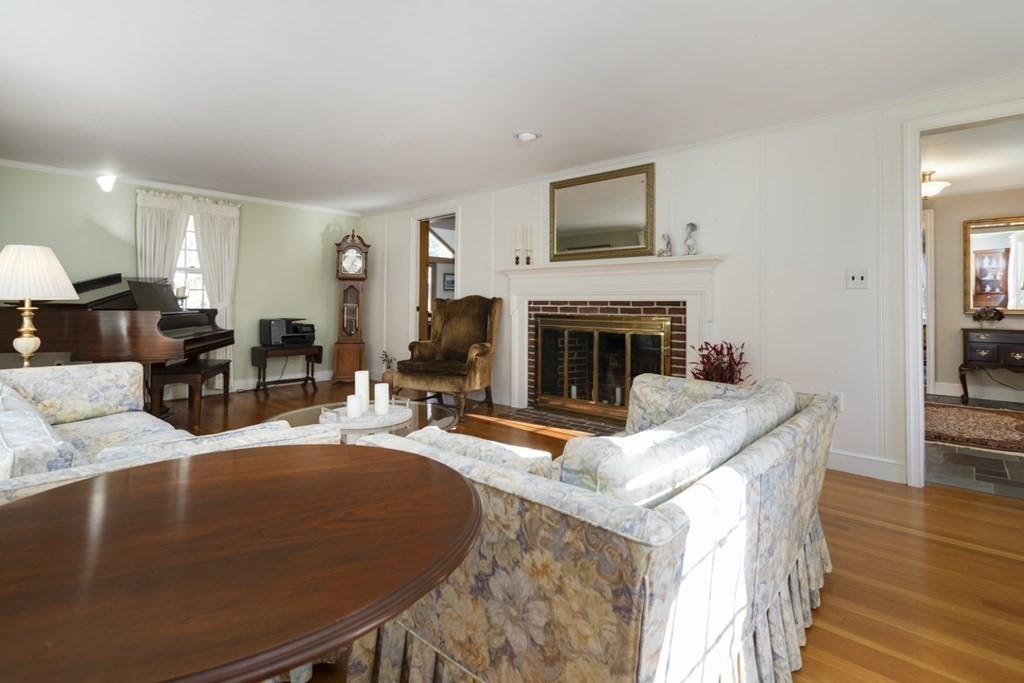 8 Townsend Road Lynnfield, MA 01940 - Photo 10 of 41 a living room with furniture a fireplace and a flat screen tv