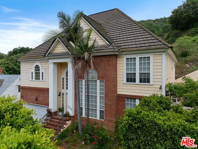 a front view of a house with a garden