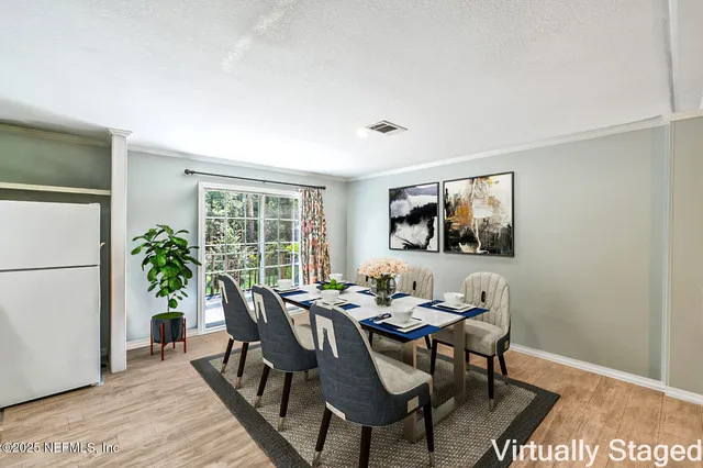 a dining room with furniture potted plants and wooden floor