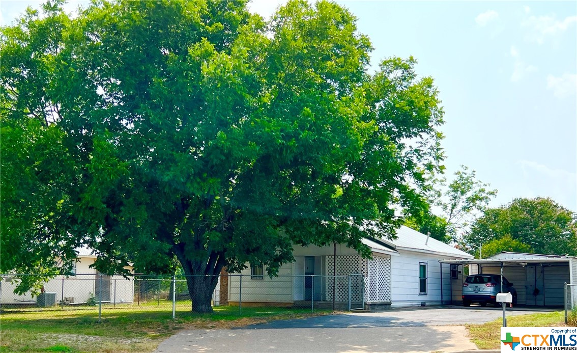 a front view of a house with a yard garage and tree