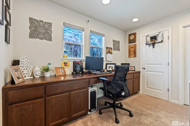 a view of a workspace with furniture and a window