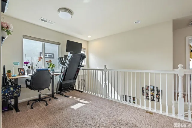 a view of a workspace with furniture and a window