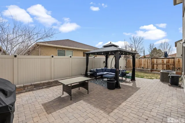 a view of a patio with table and chairs with wooden fence