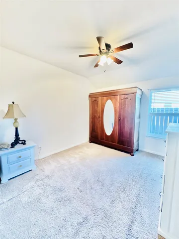 a bedroom with a bed and a ceiling fan