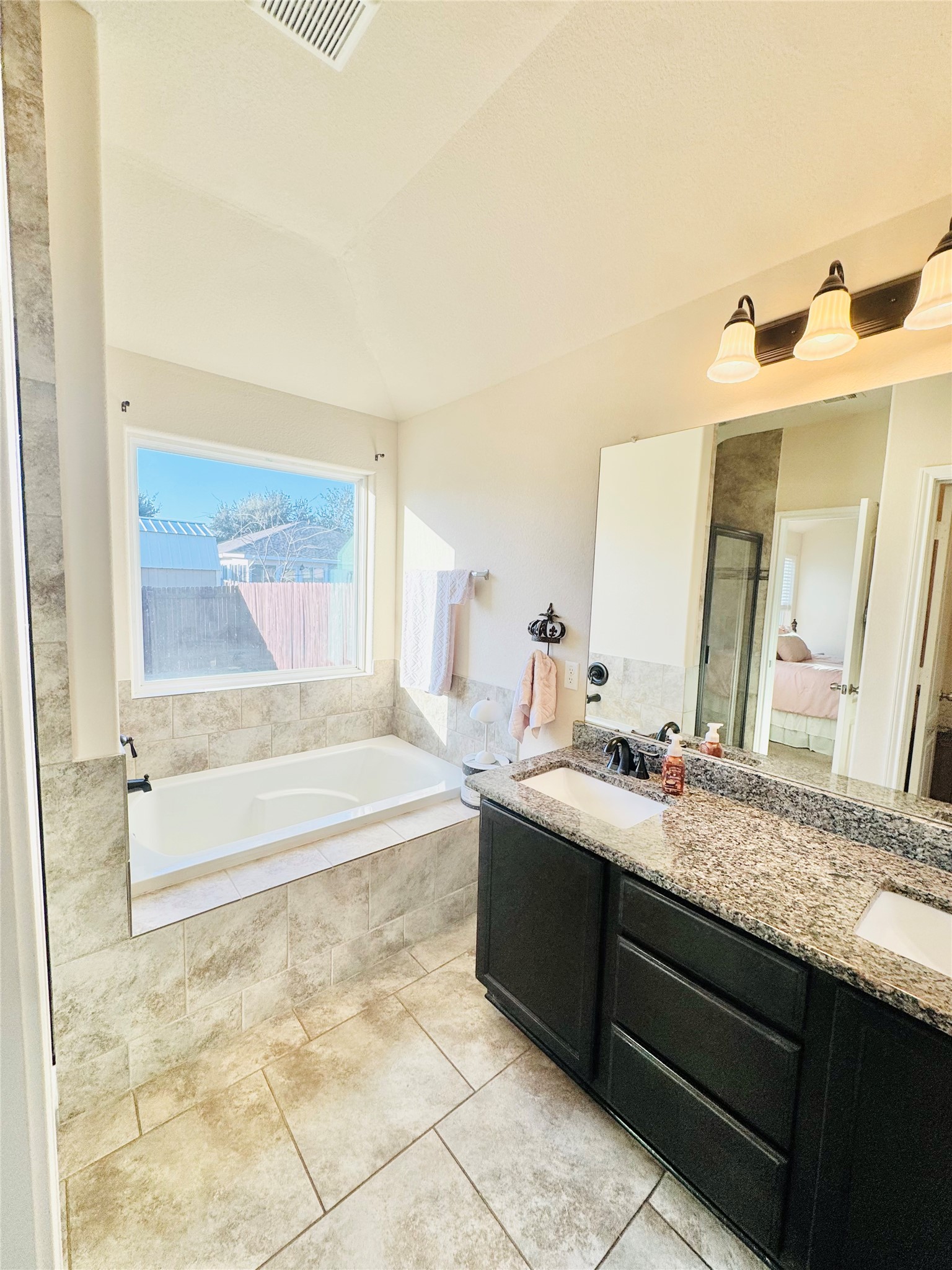 413 Gettysburg Loop Elgin, TX 78621 - Photo 27 of 32 a spacious bathroom with a granite countertop sink and a bathtub
