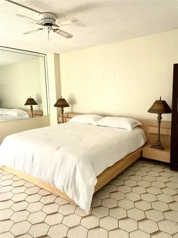 a bedroom with a bed and a lamp with the dresser