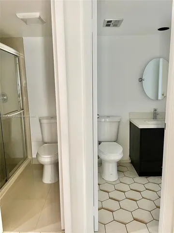 a bathroom with a toilet a sink and a mirror