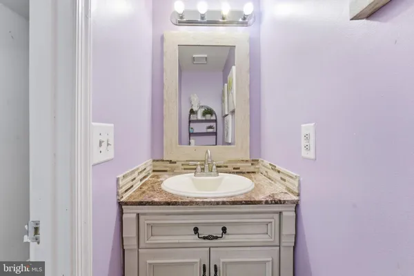 a bathroom with a granite countertop sink a mirror and a