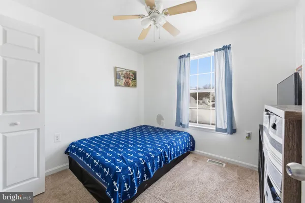 a bedroom with a bed and a flat tv screen on the dresser