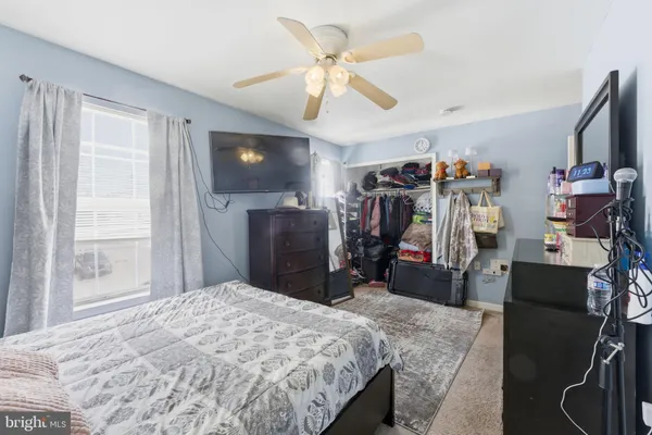 a bedroom with a bed and a flat tv screen on the dresser