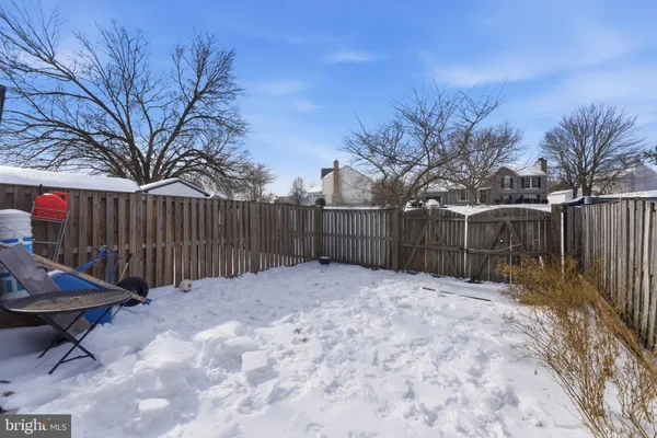 a view of backyard with wooden fence and trees
