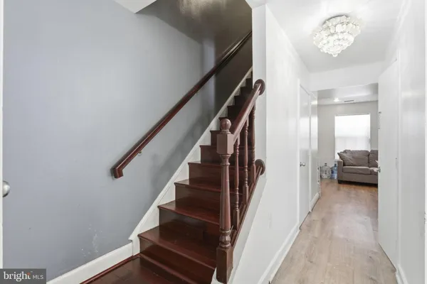a view of a hallway with wooden floor and stairs