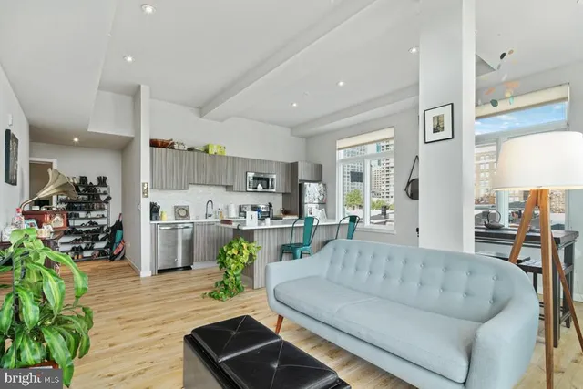 a living room with furniture and a dining table with wooden floor