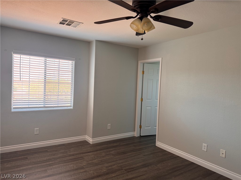 8937 Austin Ridge Avenue Las Vegas, NV 89178 - Photo 9 of 22 A well-lit bedroom with rich wood flooring offers a serene personal retreat.