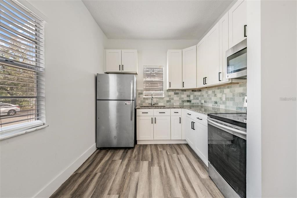 8304 North 13th Street Tampa, FL 33604 - Photo 6 of 22 a kitchen with a refrigerator sink stove and cabinets