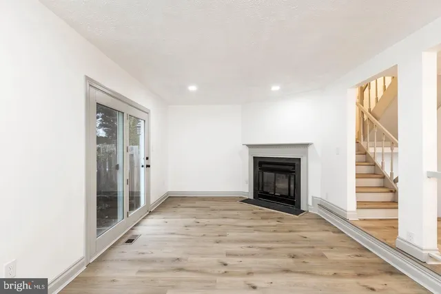 a view of an empty room with a window and fireplace