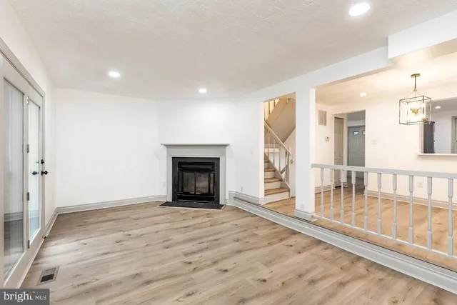 a view of empty room with wooden floor and fireplace