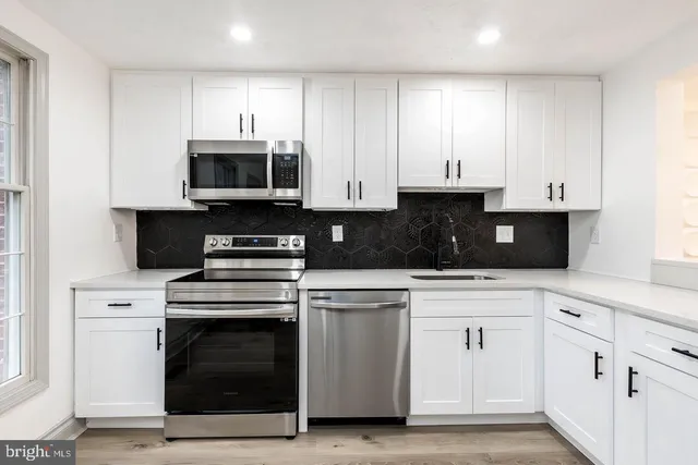 a kitchen with stainless steel appliances granite countertop a stove a microwave and cabinets
