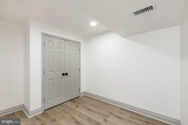 a view of a house with a large tree and wooden fence