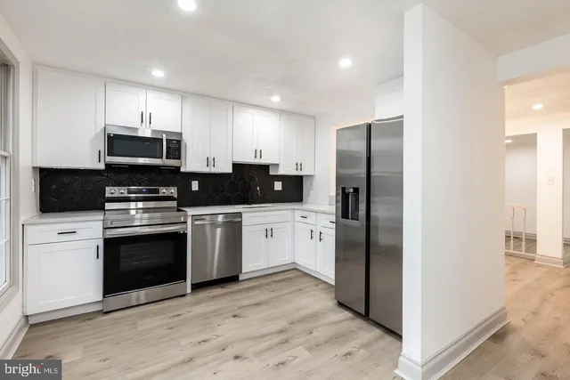 a kitchen with a refrigerator and a stove top oven