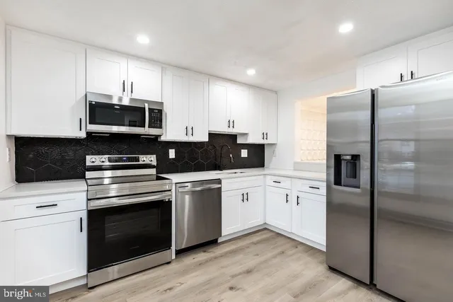 a kitchen with granite countertop a refrigerator stove and microwave